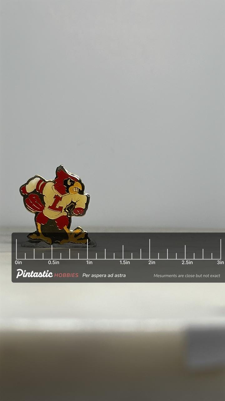 Louisville Cardinals Mascot Pin: Red Enamel Metal - Vintage Sports Accessory with ruler overlay for size reference
