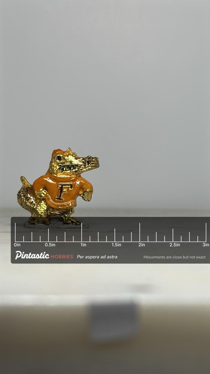 Florida Gator Mascot Pin: Gold Enamel Finish - Vintage Sports Accessory with ruler overlay for size reference