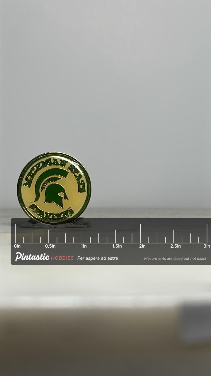 Michigan State Spartans Enamel Pin: Green & Gold Round - Vintage College Accessory with ruler overlay for size reference