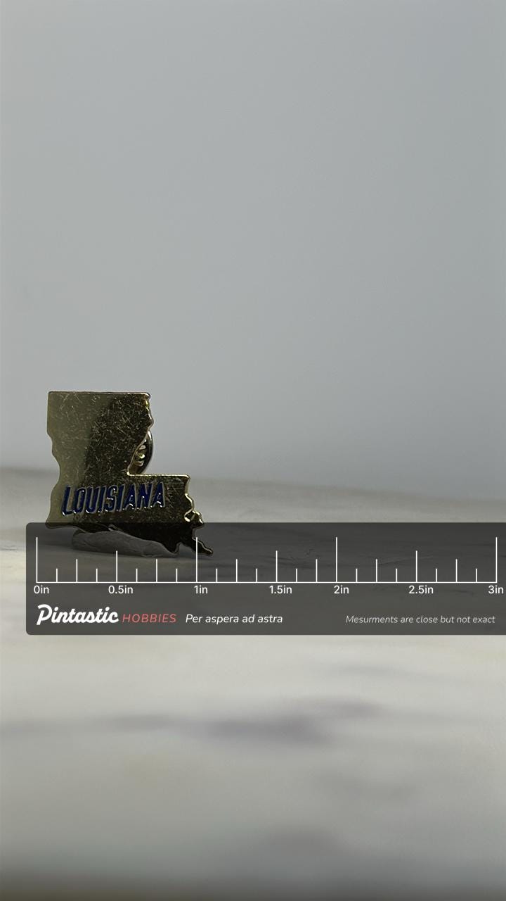 Louisiana State Enamel Pin: Gold with Blue Lettering - Vintage Souvenir Accessory with ruler overlay for size reference