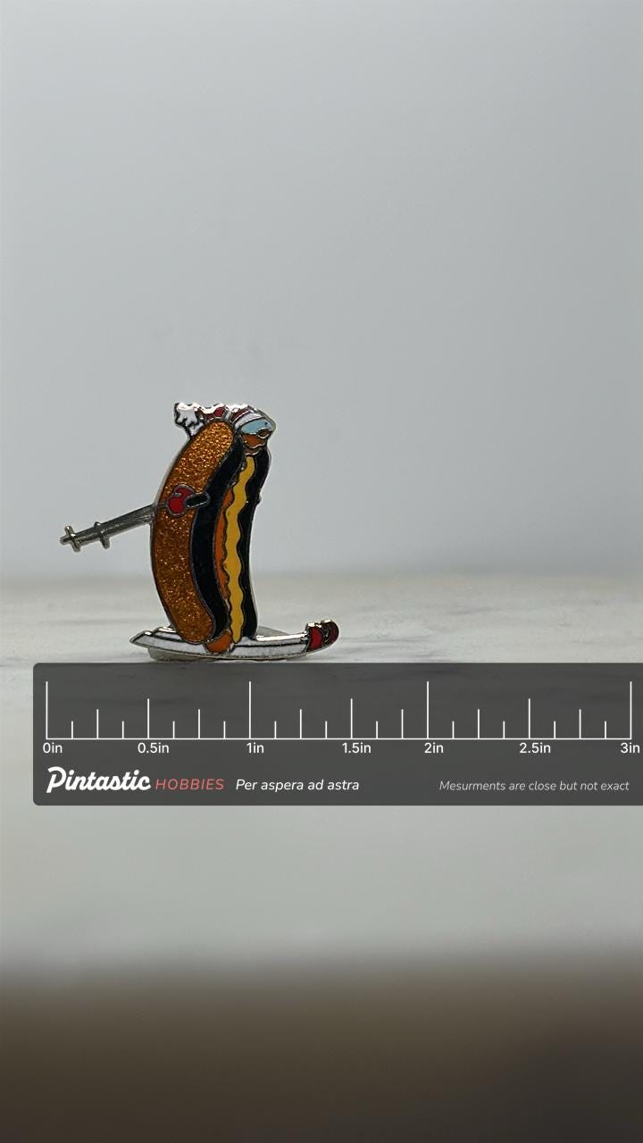 Skiing Hot Dog Enamel Pin: Colorful Cloisonné - Retro Novelty Accessory with ruler overlay for size reference