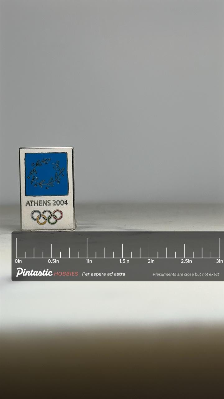 Athens 2004 Olympic Pin: Silver & Blue Enamel - Sports Memorabilia Accessory with ruler overlay for size reference