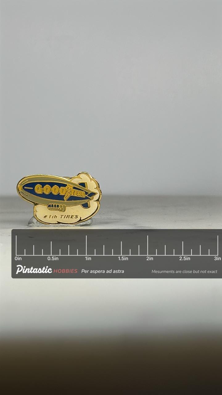 Goodyear Blimp Enamel Pin: Gold & Blue Logo - Retro Company Accessory with ruler overlay for size reference