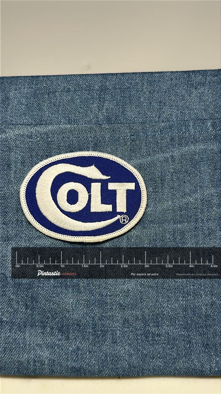 Colt Collectable Patch: Iron-On Blue White Oval - Firearm Logo Accessory with ruler overlay for size reference