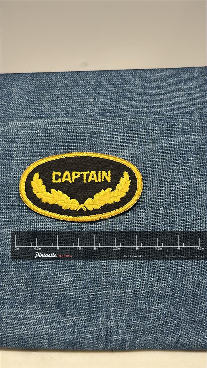 Captain Collectable Patch: Iron-On Black and Gold Oval - Vintage Accessory with ruler overlay for size reference