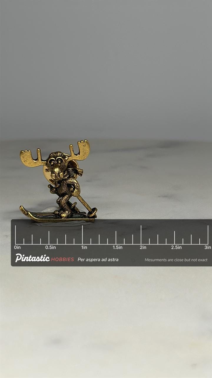 Moose Skiing Pin: Antique Gold Finish - Whimsical Winter Accessory with ruler overlay for size reference