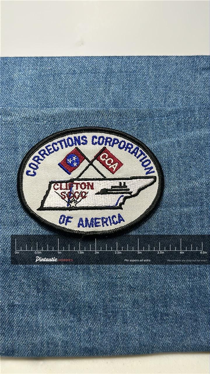 Corrections Corporation Collectable Patch: Iron-On Oval Red/Blue - Gov/Prison Accessory with ruler overlay for size reference