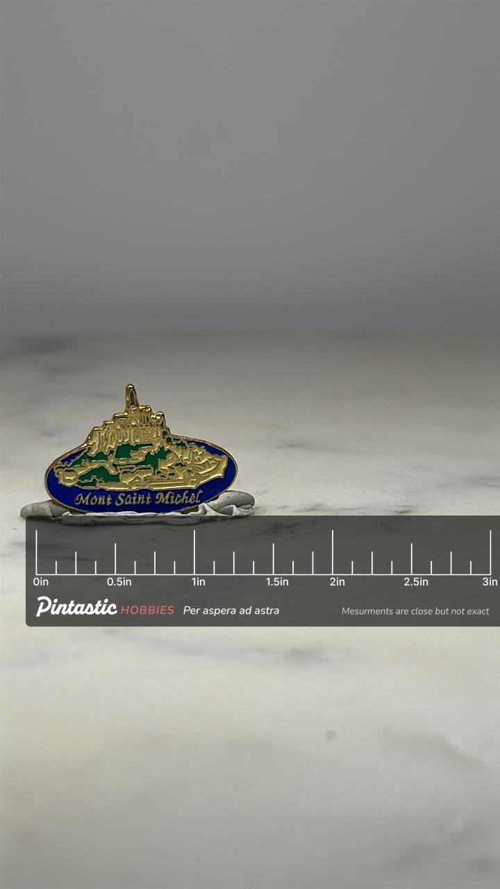 Mont Saint Michel Souvenir Pin: Goldtone Enamel - Travel Landmark Accessory with ruler overlay for size reference