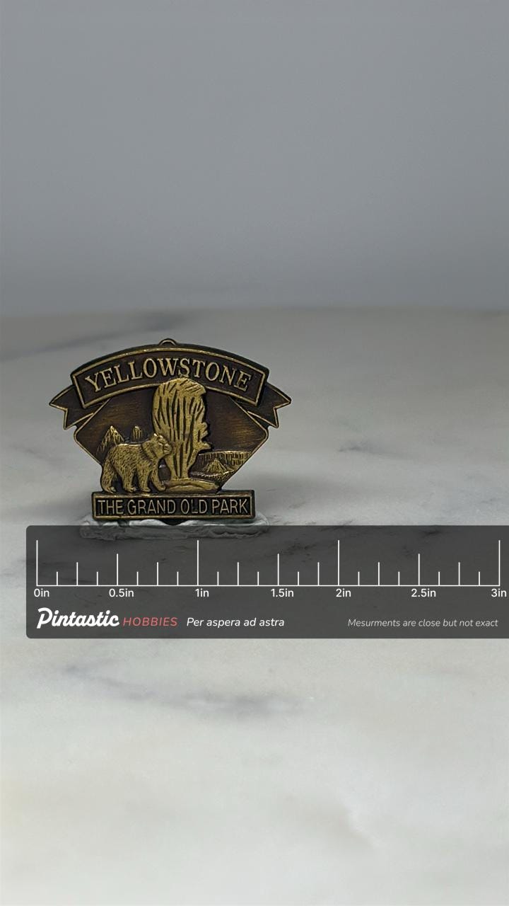 Yellowstone National Park Pin: Antiqued Brass Finish - Vintage Souvenir Accessory with ruler overlay for size reference