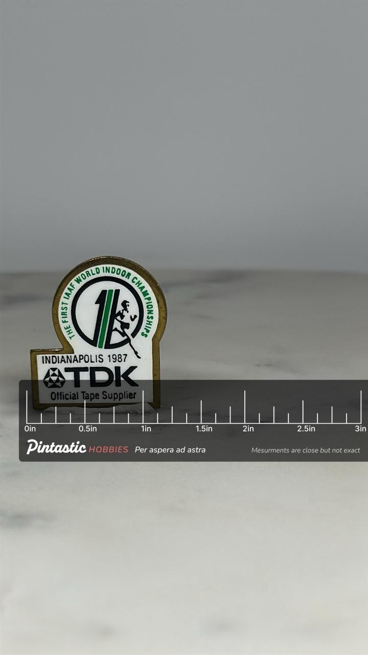 IAAF 1987 TDK Lapel Pin: White Brass Enamel - Track & Field Accessory with ruler overlay for size reference