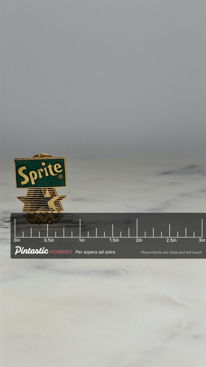 Sprite Olympic Pin: Gold Enamel Logo - 90s Sports Accessory with ruler overlay for size reference