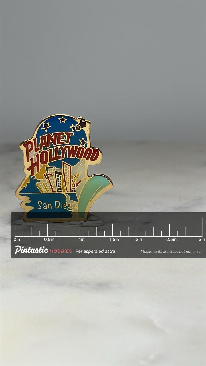 Planet Hollywood San Diego Pin: Gold Enamel Skyline - 90s Collectible Accessory with ruler overlay for size reference