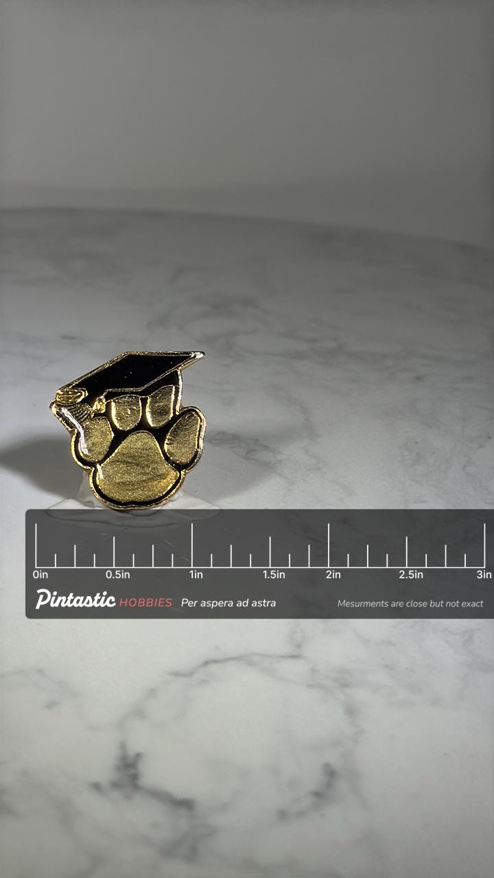 Graduation Paw Print Pin: Gold & Black Enamel - School Spirit Accessory with ruler overlay for size reference