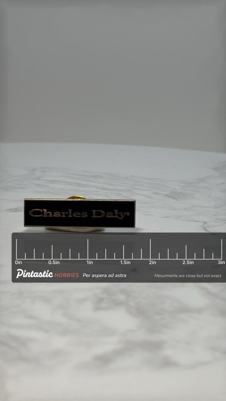 Charles Daly Nameplate Pin: Black & Gold Enamel - Vintage Accessory with ruler overlay for size reference