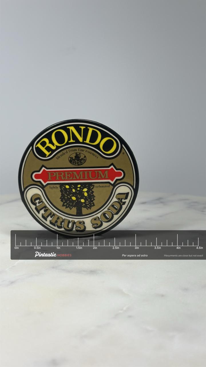 Rondo Citrus Soda Advertising Button Pin: Brown Logo - Vintage Beverage with ruler overlay for size reference