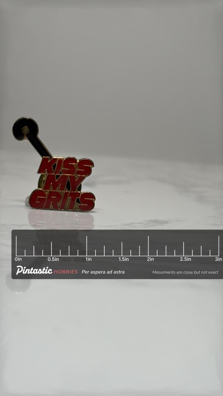 Kiss My Grits Enamel Pin: Red Gold Retro - 1980s TV Accessory with ruler overlay for size reference