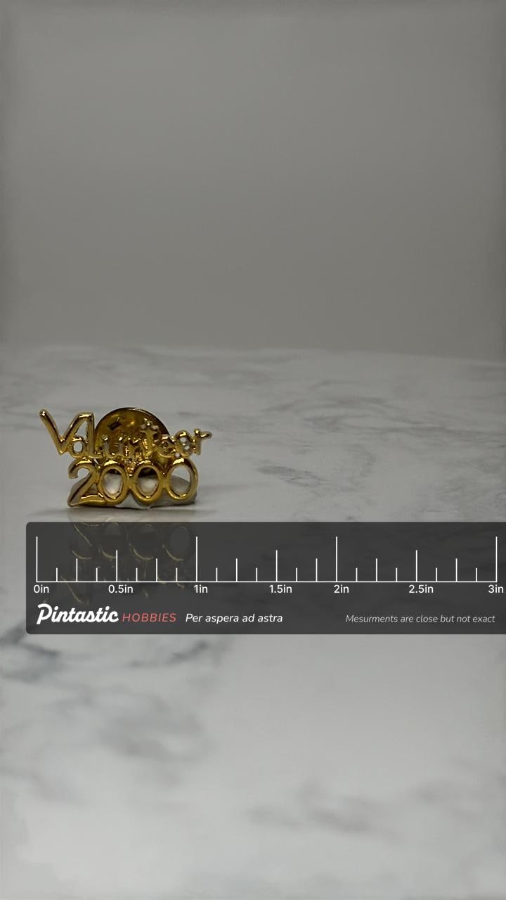 Volunteer 2000 Lapel Pin: Gold Tone Script - Y2K Era Accessory with ruler overlay for size reference
