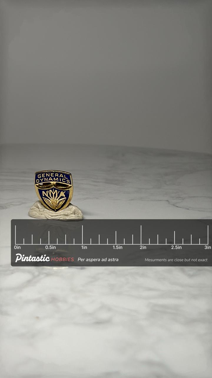 General Dynamics NMA Shield Pin: Blue & Gold Enamel - Corporate with ruler overlay for size reference