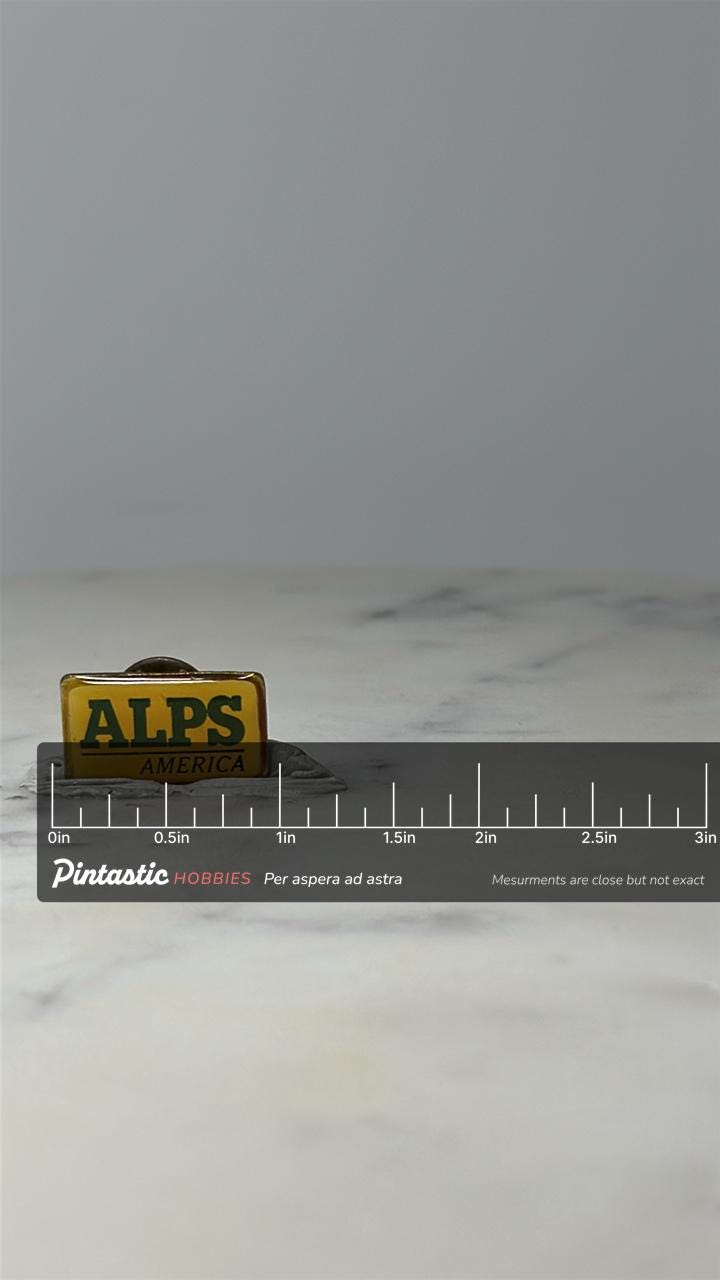 Vintage ALPS America Advertising Pin: Yellow Enamel - Retro Brand Accessory with ruler overlay for size reference
