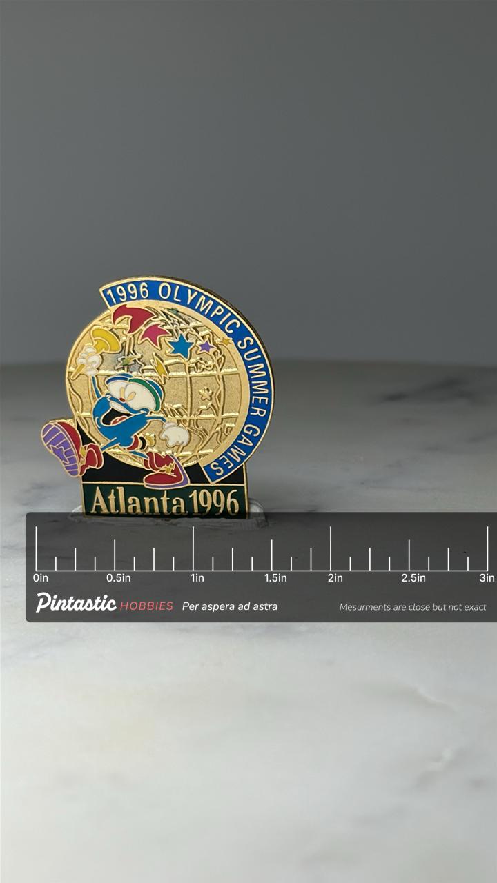 Vintage 1996 Atlanta Olympic Izzy Enamel Pin: Gold Tone - Summer Games Accessory with ruler overlay for size reference
