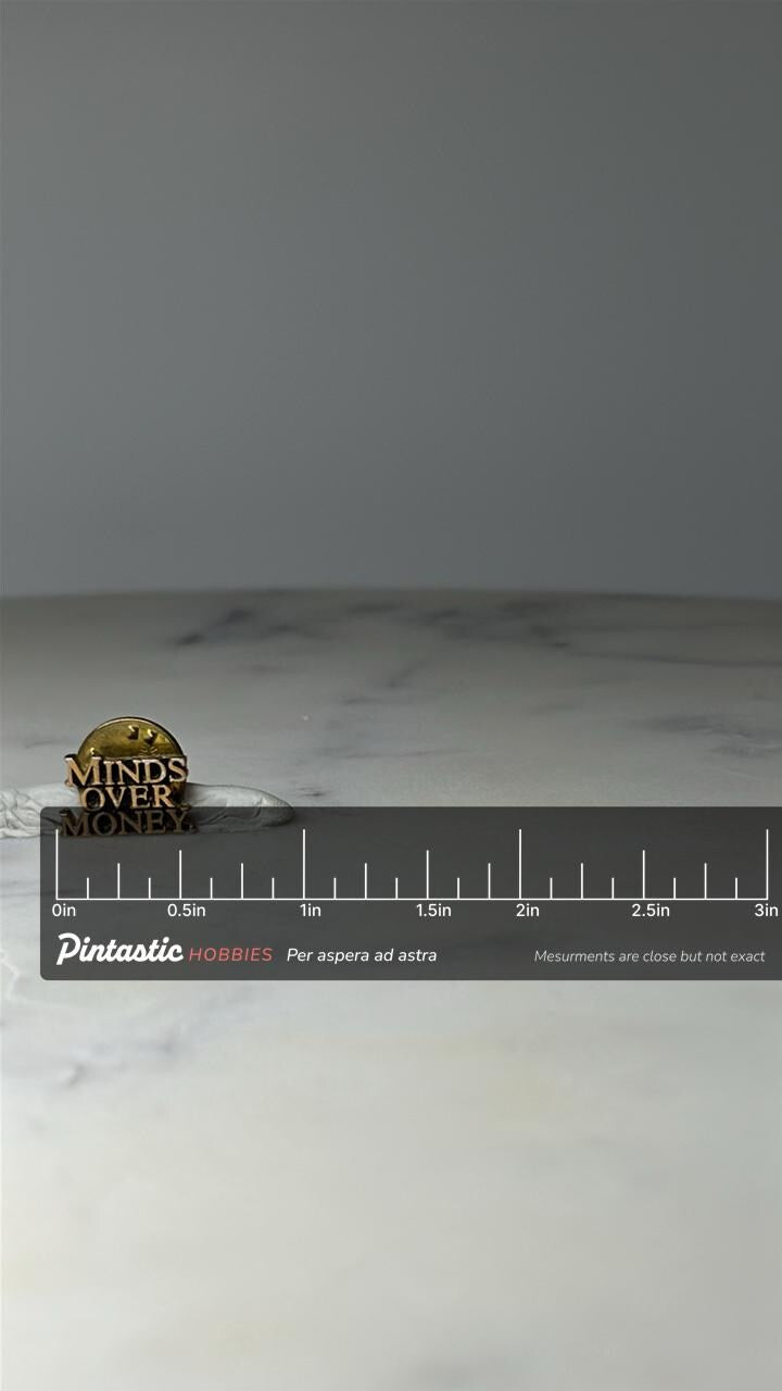 Vintage Minds Over Money Lapel Pin: Gold Tone - Motivational Accessory with ruler overlay for size reference