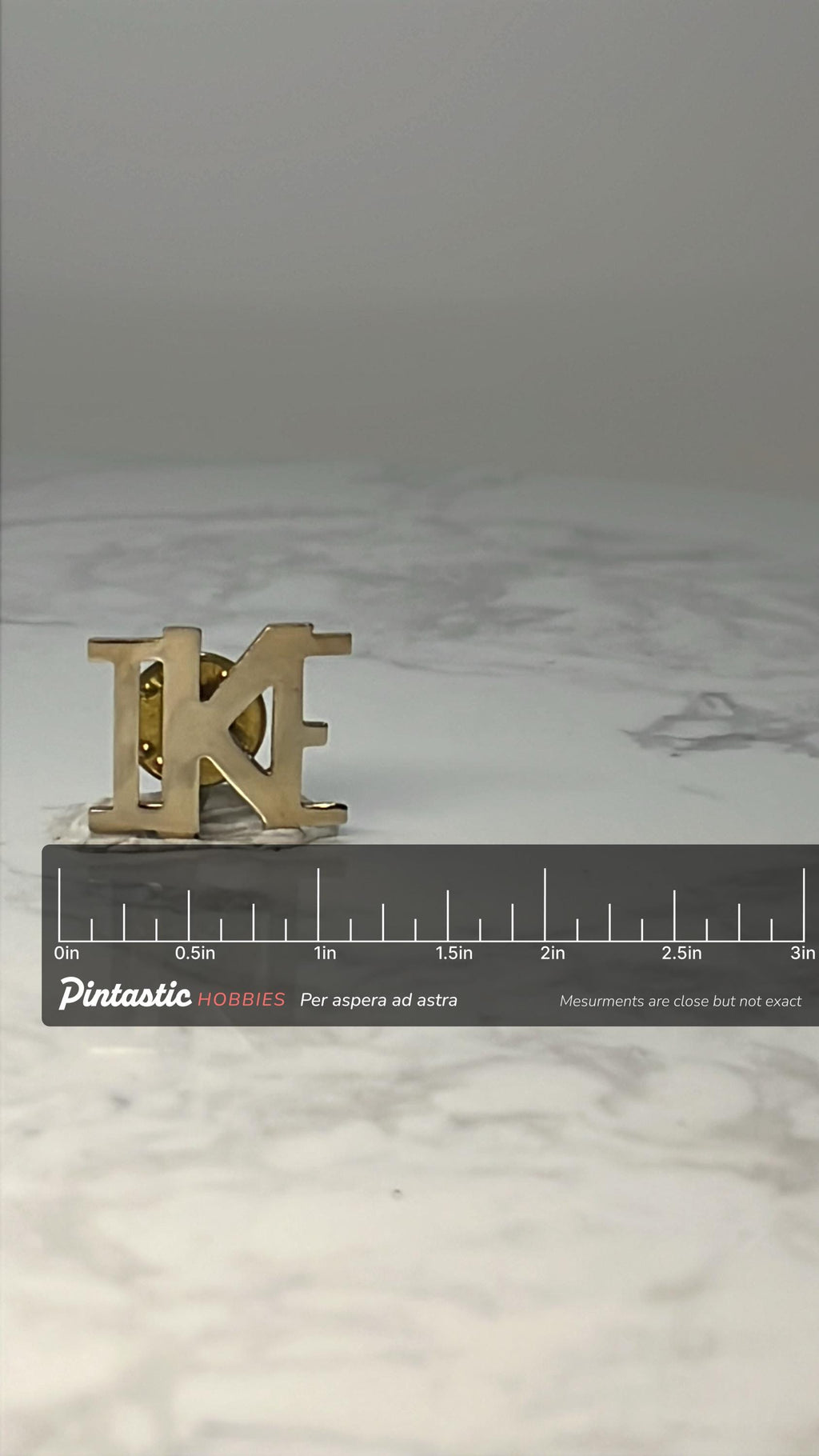 Vintage IKE Letter Lapel Pin: Gold Tone - Political Campaign Accessory with ruler overlay for size reference