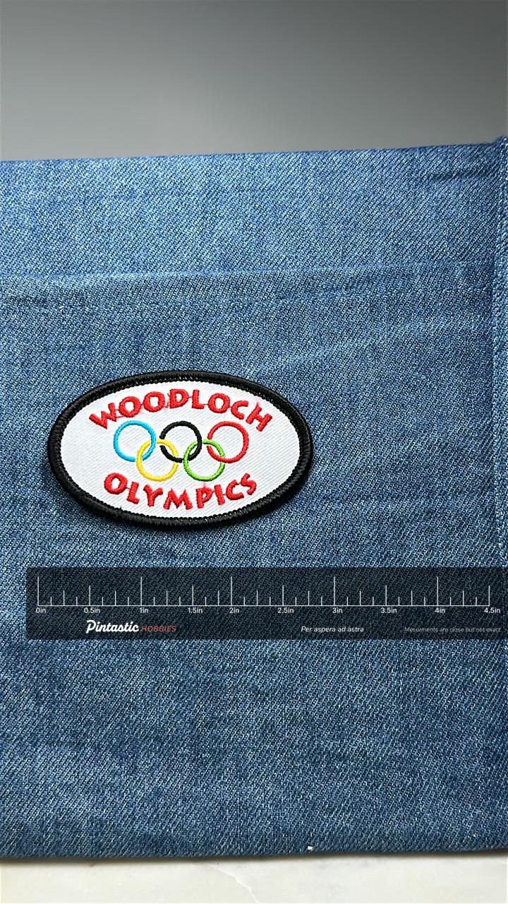 Woodloch Olympics Patch: Multicolor Oval - Resort Sports Accessory with ruler overlay for size reference