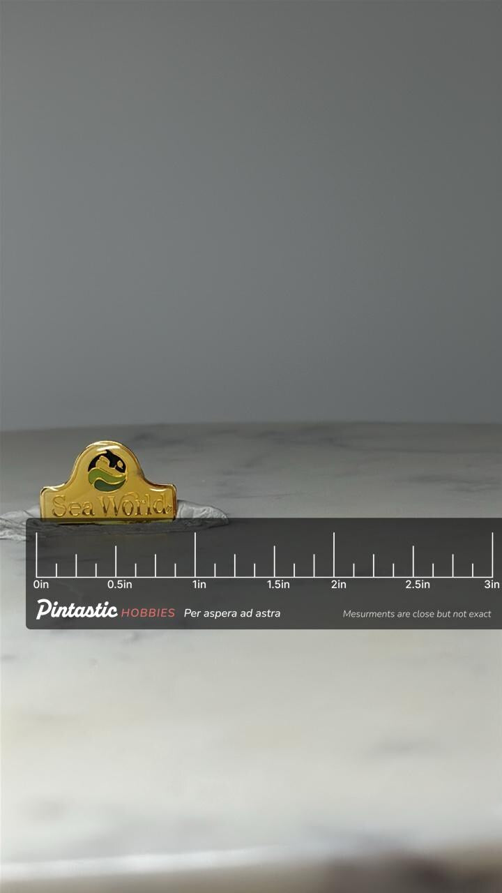 Vintage SeaWorld Souvenir Pin: Gold Tone Enamel - Theme Park Accessory with ruler overlay for size reference