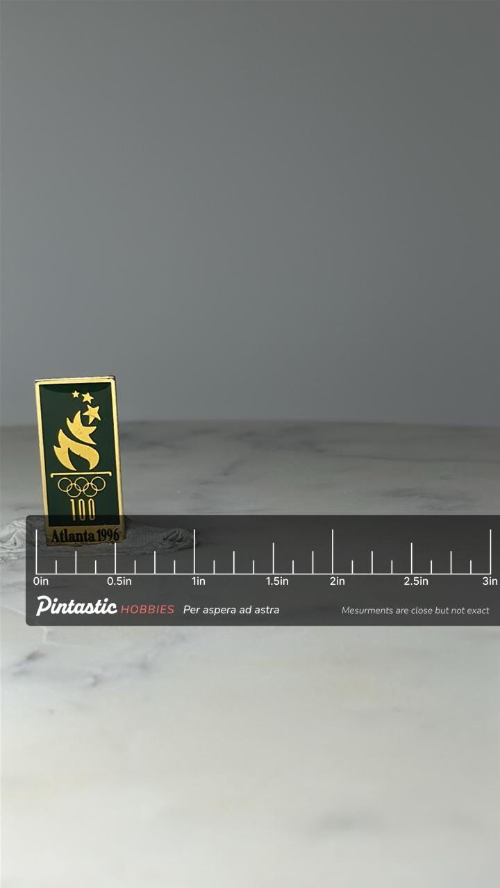 Vintage Atlanta 1996 Olympic Pin: Green Gold Enamel - Centennial Games with ruler overlay for size reference