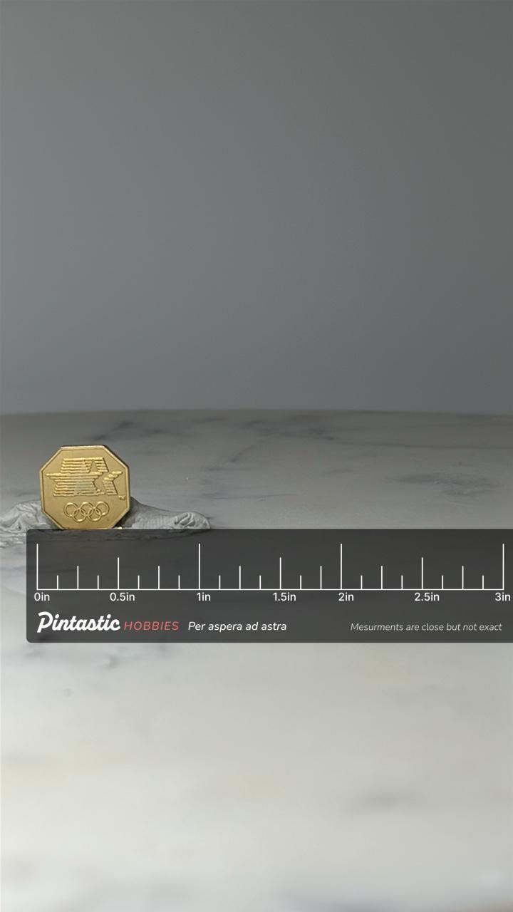 Vintage Olympic Lapel Pin: Gold Tone - 1980s Sports Accessory with ruler overlay for size reference