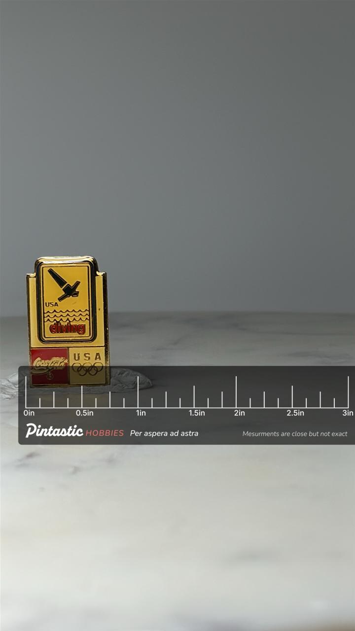 Vintage USA Olympic Diving Pin: Gold Tone Enamel - Coca Cola Sponsor with ruler overlay for size reference