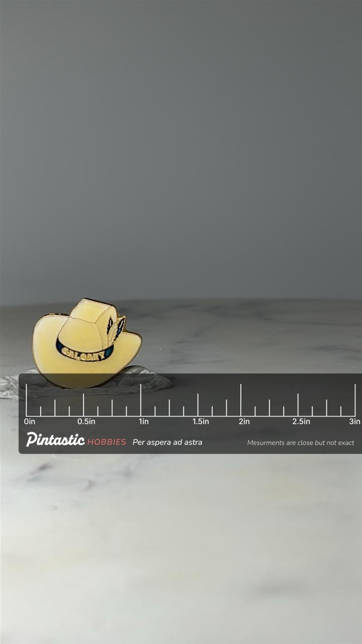 Vintage Calgary Cowboy Hat Pin: Cream Enamel - Western Souvenir Accessory with ruler overlay for size reference
