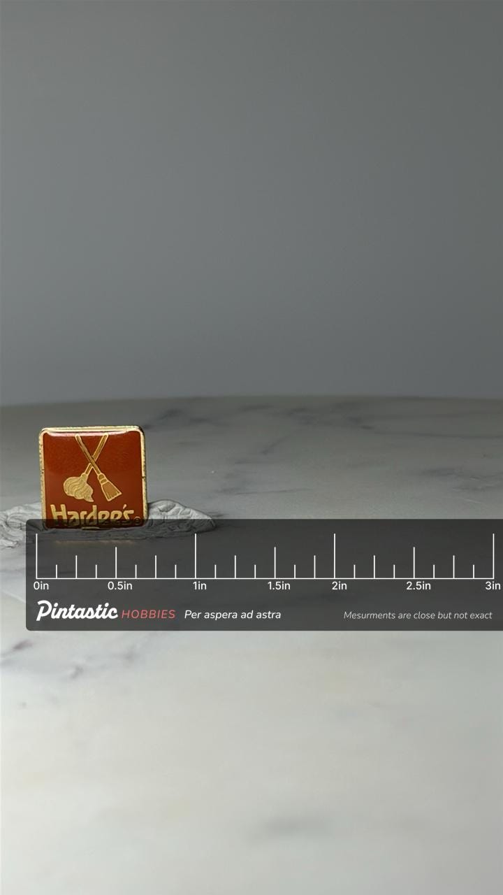 Vintage Hardees Mop and Broom Logo Enamel Pin: Gold Tone Orange - 1980s Fast Food Accessory with ruler overlay for size refer