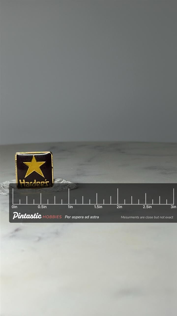 Vintage Hardees Star Logo Lapel Pin: Black & Gold Enamel - Fast Food with ruler overlay for size reference