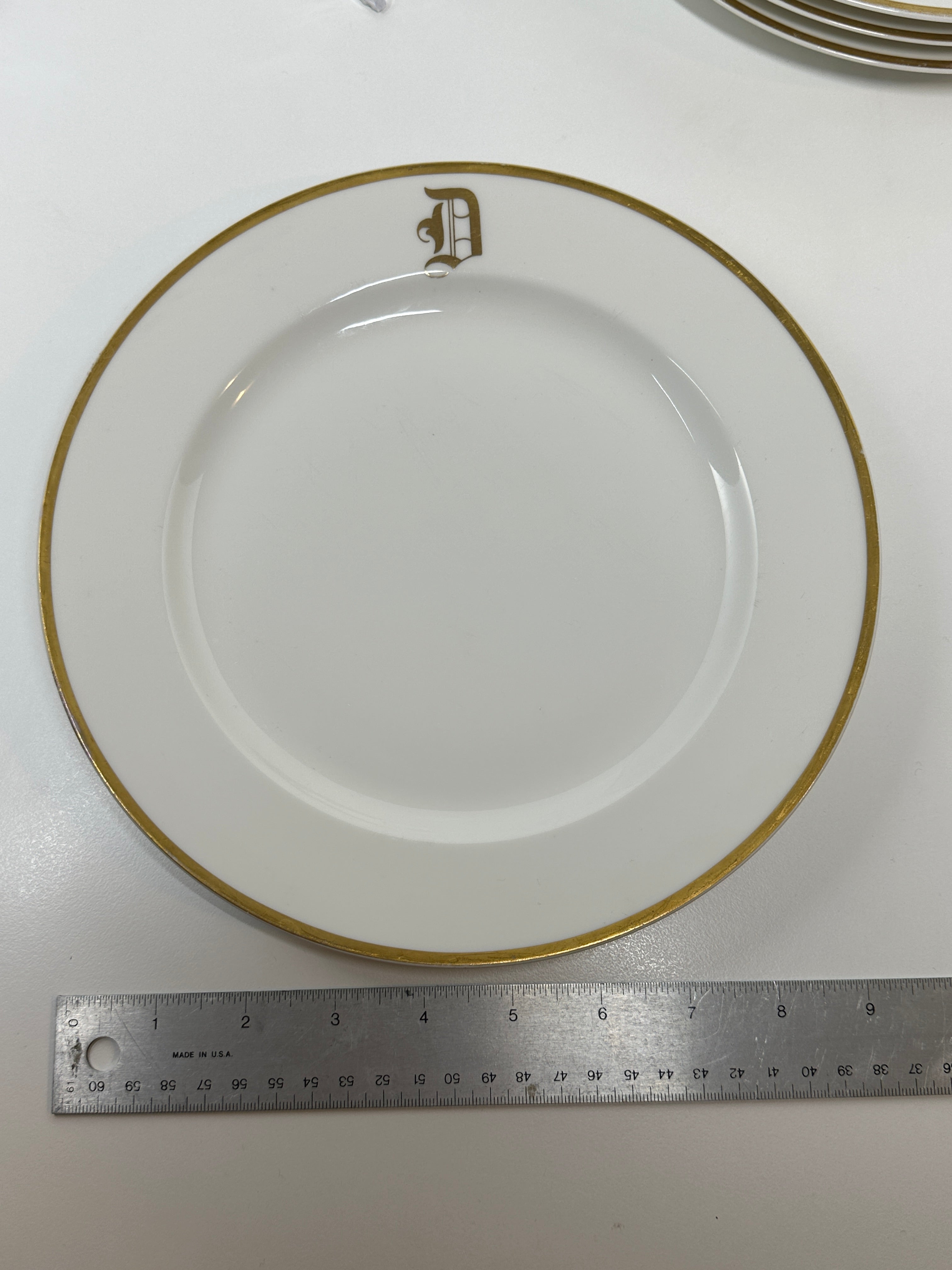 Set of four Haviland France white dinner plates with gold trim and monogram letter D