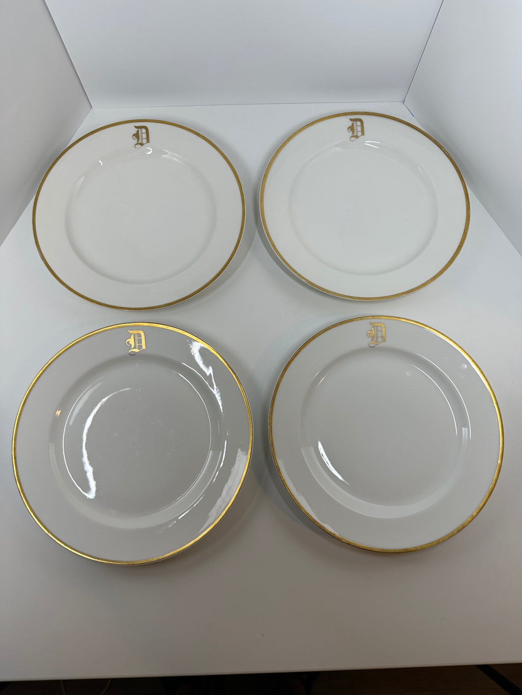 Set of four Haviland France white dinner plates with gold trim and monogram letter D