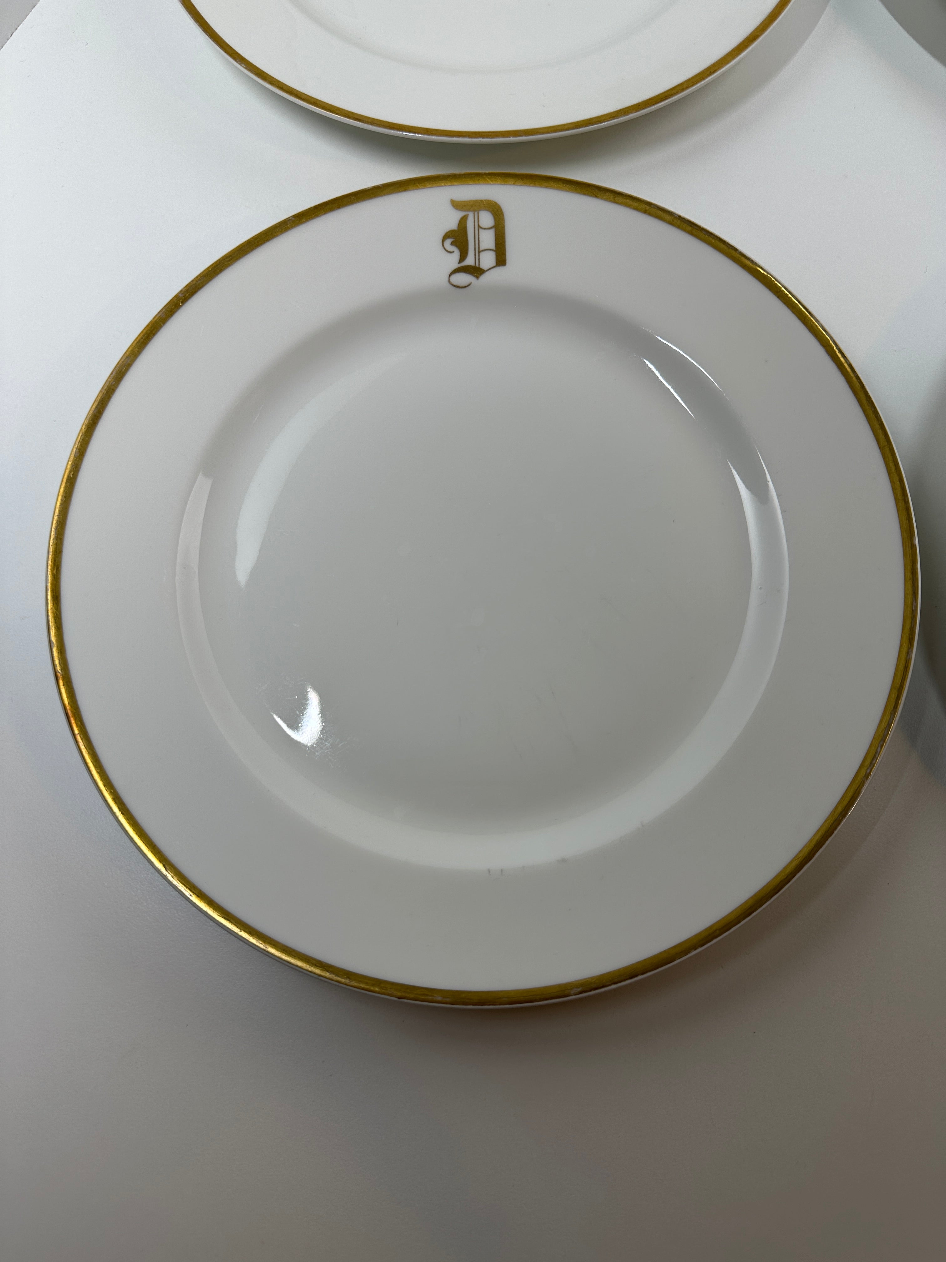 Set of four Haviland France white dinner plates with gold trim and monogram letter D