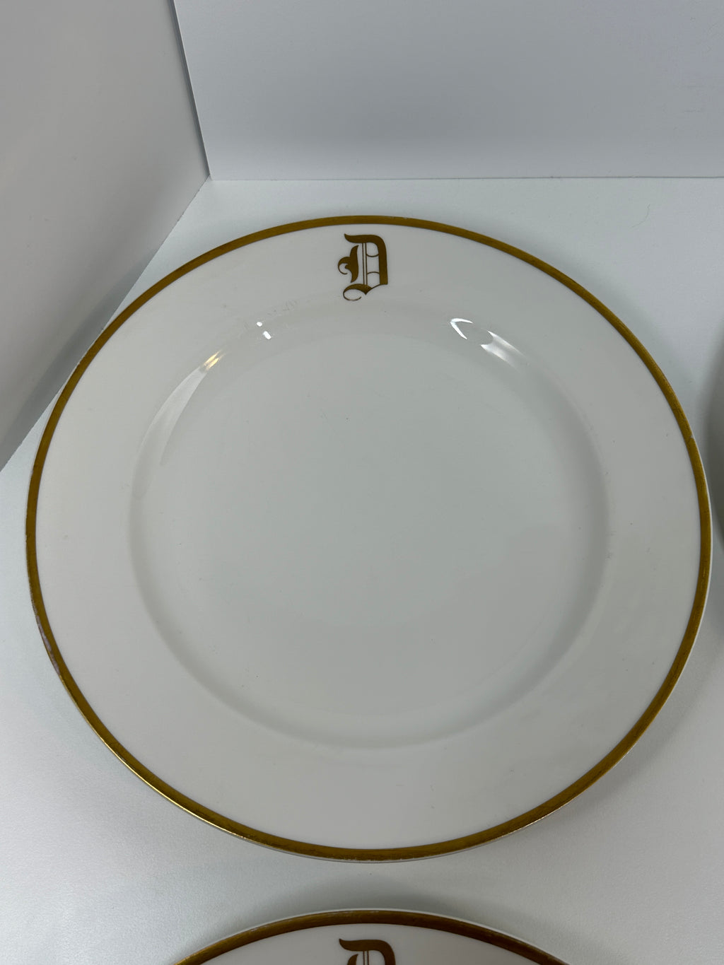 Set of four Haviland France white dinner plates with gold trim and monogram letter D