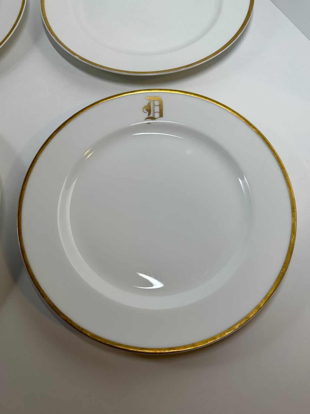 Set of four Haviland France white dinner plates with gold trim and monogram letter D