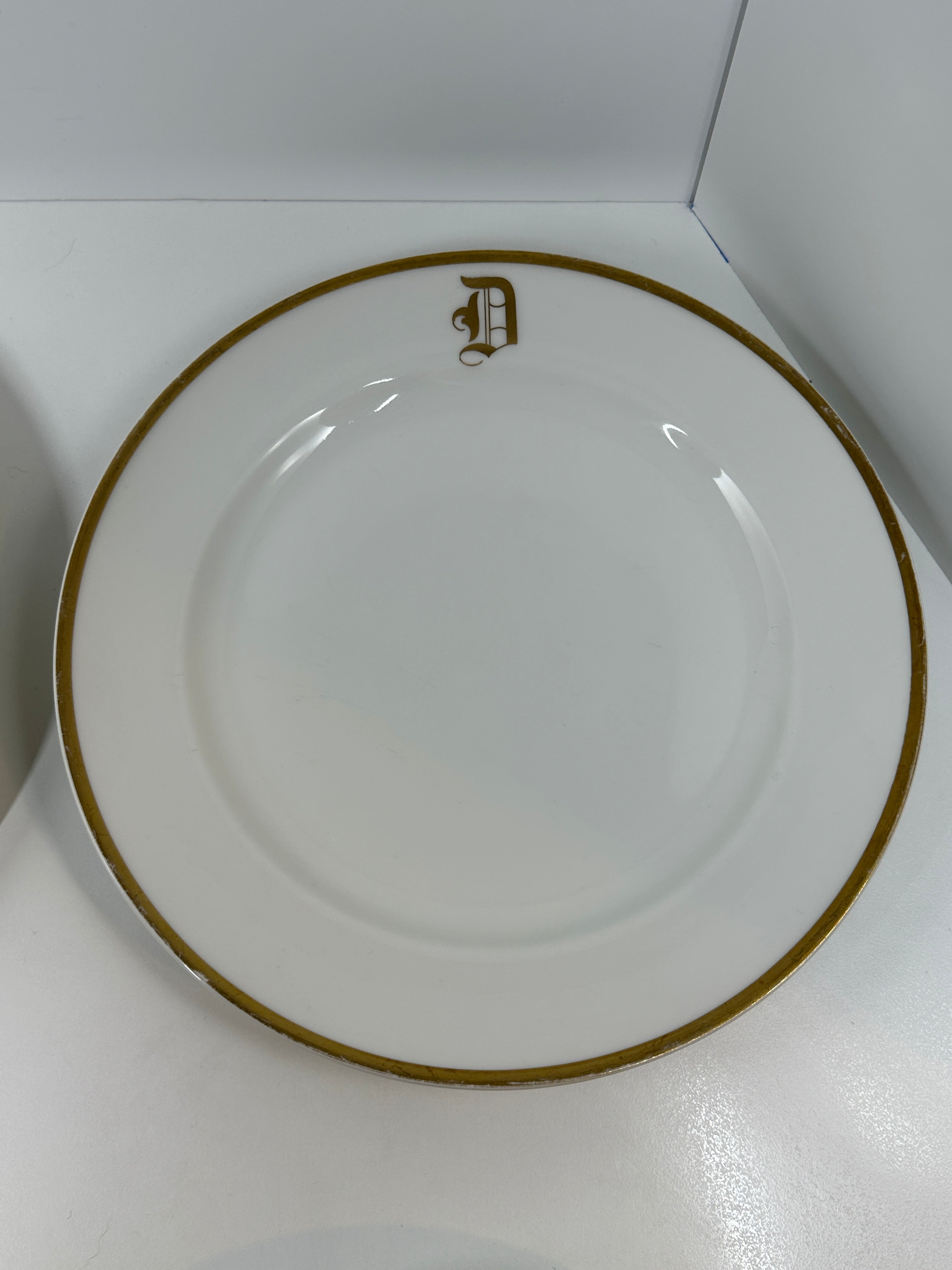 Set of four Haviland France white dinner plates with gold trim and monogram letter D