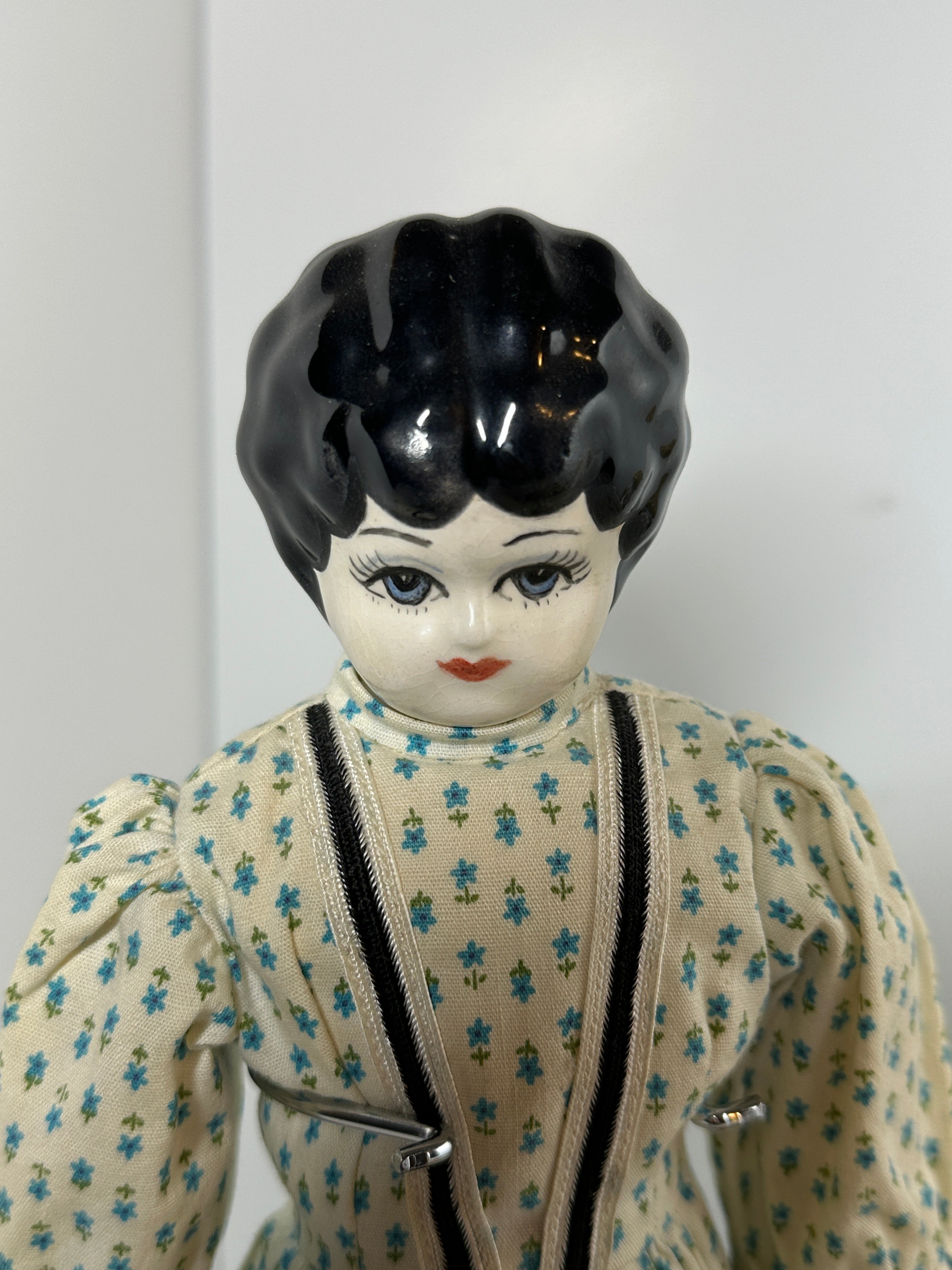 Vintage porcelain china head doll set with two dolls in period clothing, one standing and one seated with lace dress