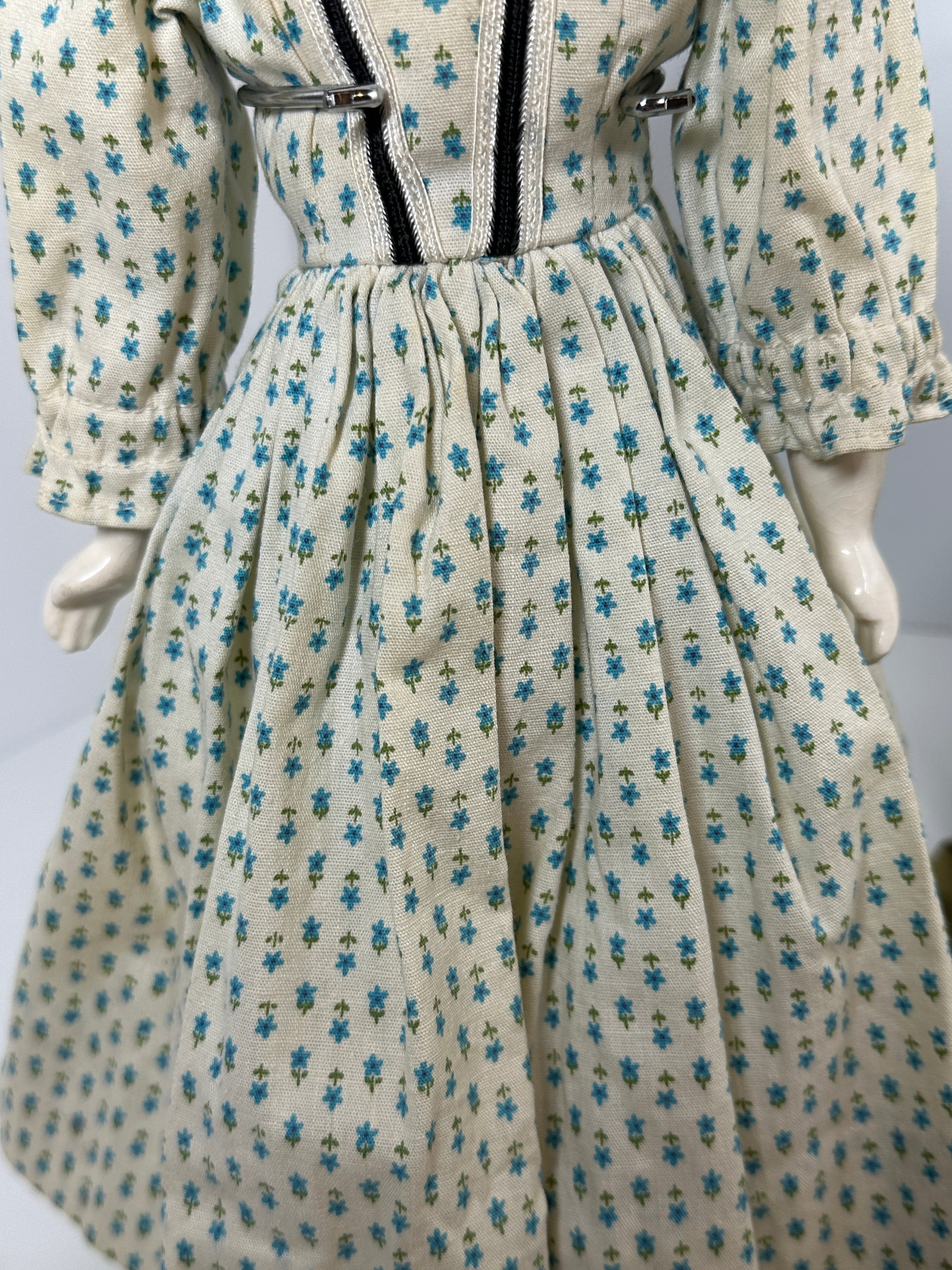 Vintage porcelain china head doll set with two dolls in period clothing, one standing and one seated with lace dress
