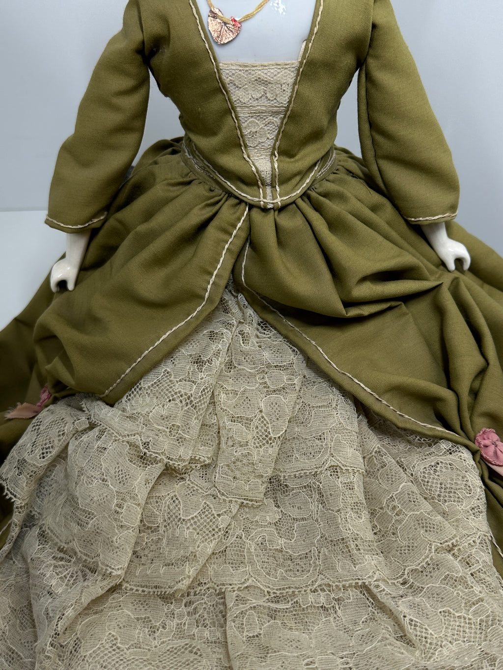Vintage porcelain china head doll set with two dolls in period clothing, one standing and one seated with lace dress