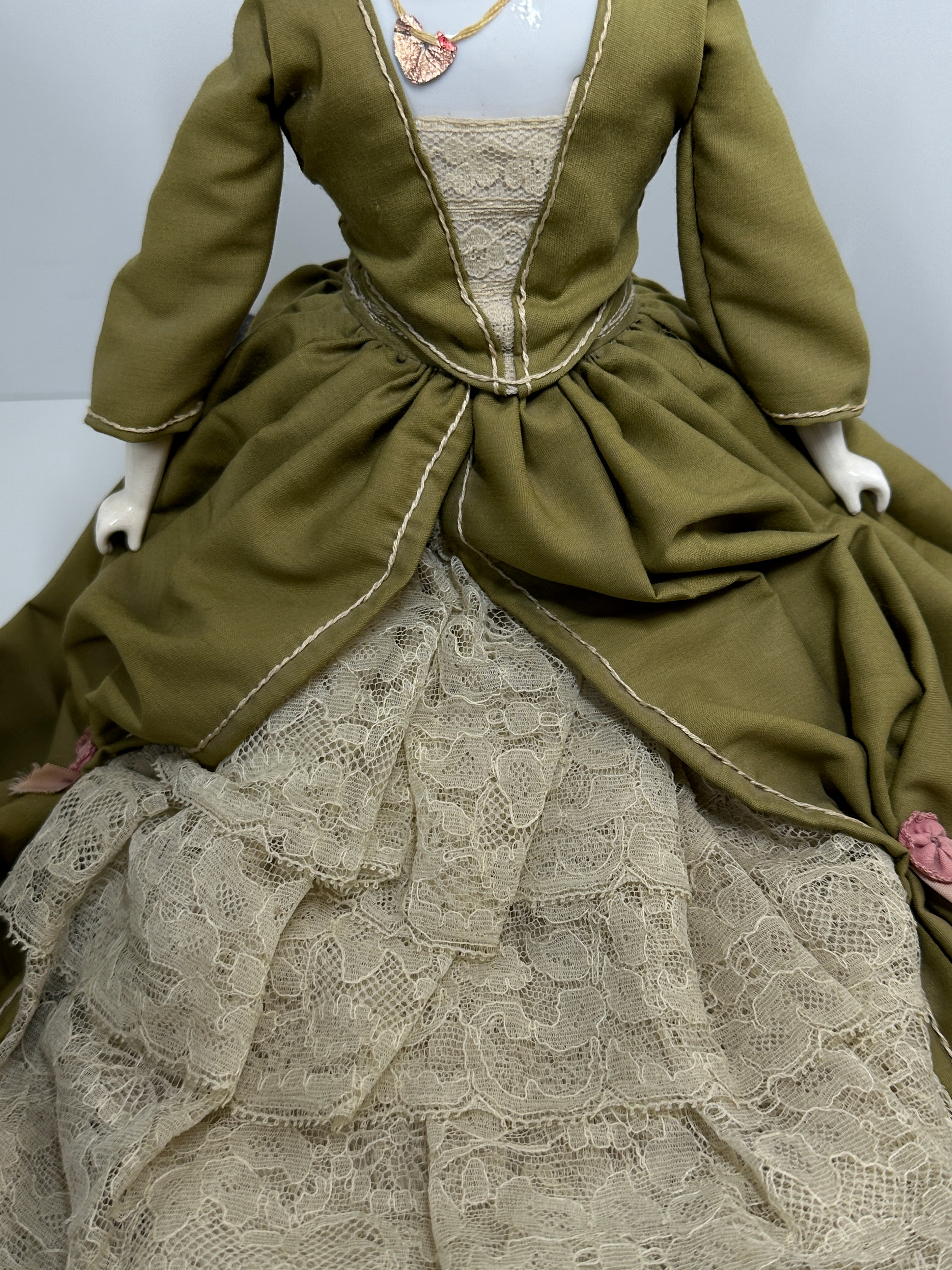 Vintage porcelain china head doll set with two dolls in period clothing, one standing and one seated with lace dress