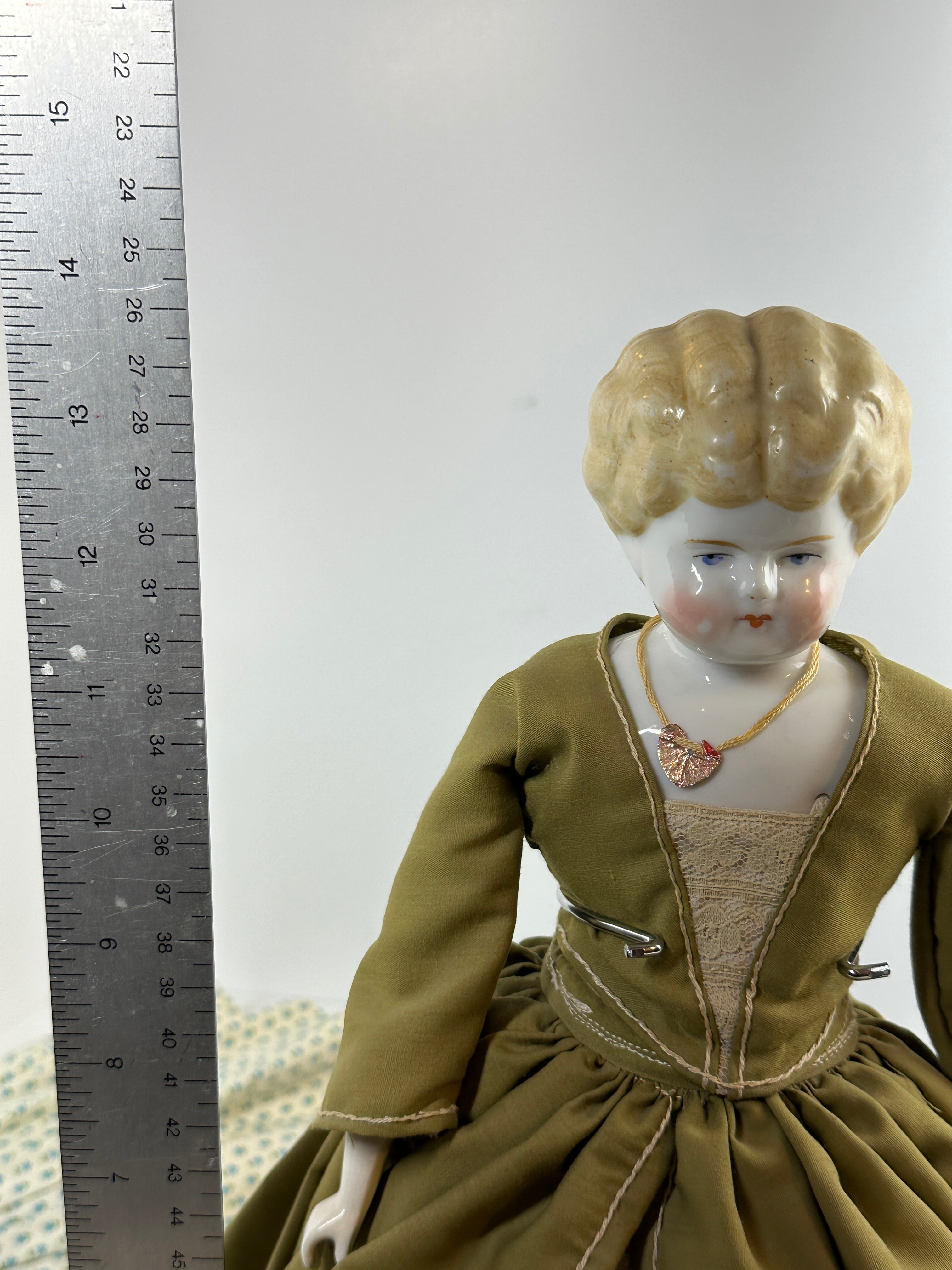 Vintage porcelain china head doll set with two dolls in period clothing, one standing and one seated with lace dress