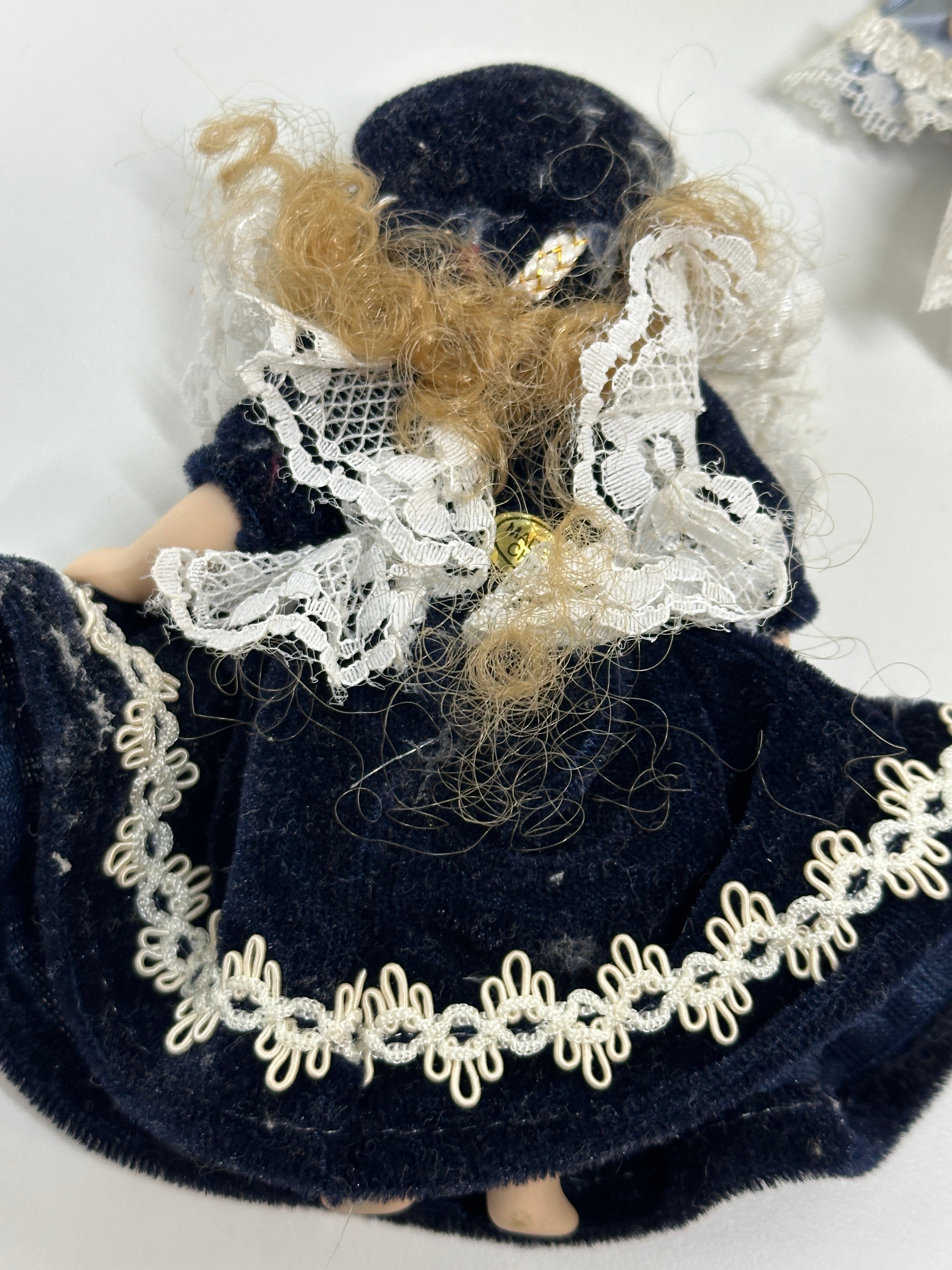 Set of two miniature porcelain dolls wearing blue vintage style lace dresses with painted faces