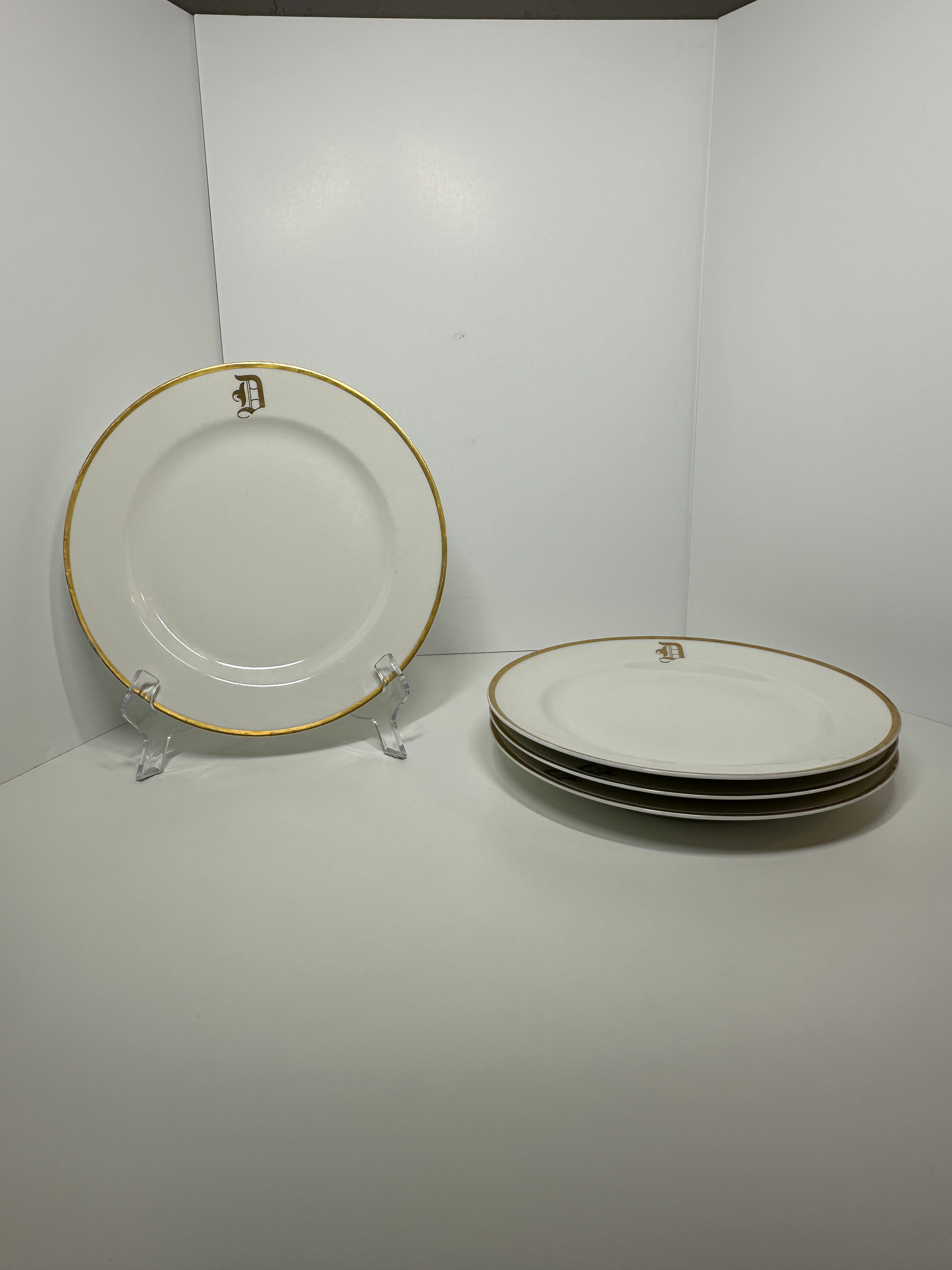 Set of four Haviland France white dinner plates with gold trim and monogram letter D