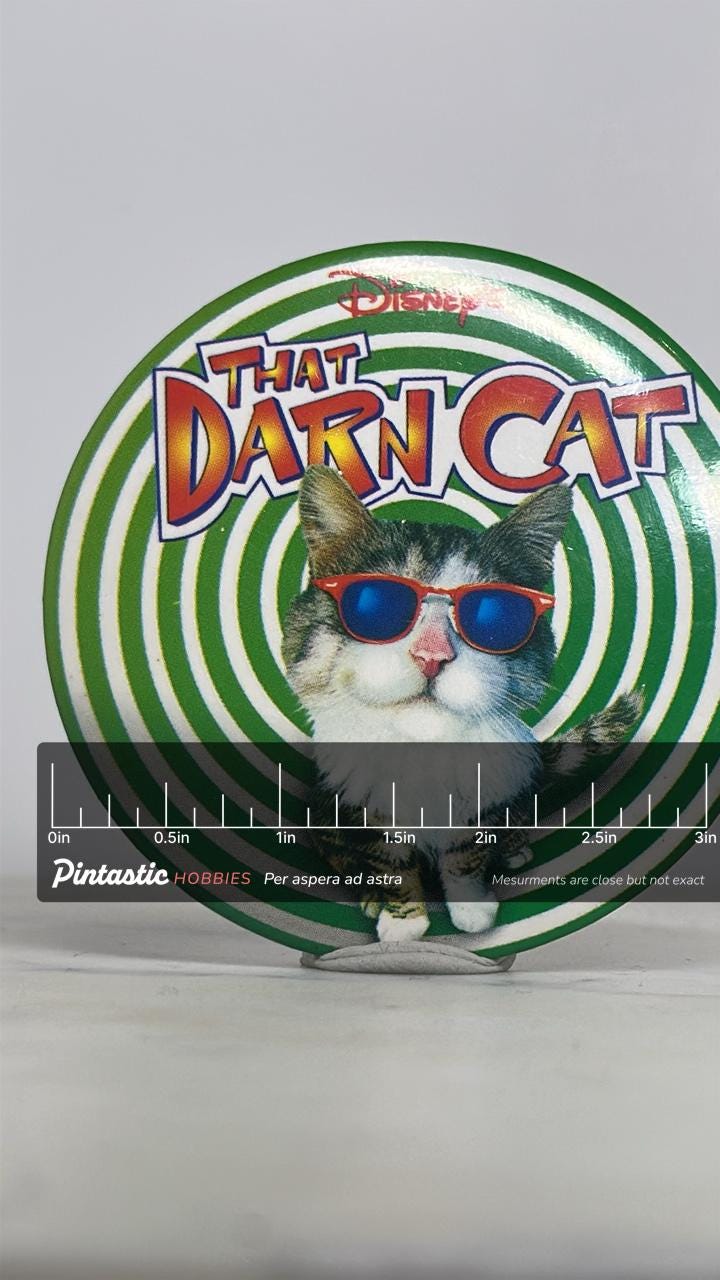 That Darn Cat Pinback Button: Glossy Green Spiral - 90s Disney Accessory with ruler overlay for size reference