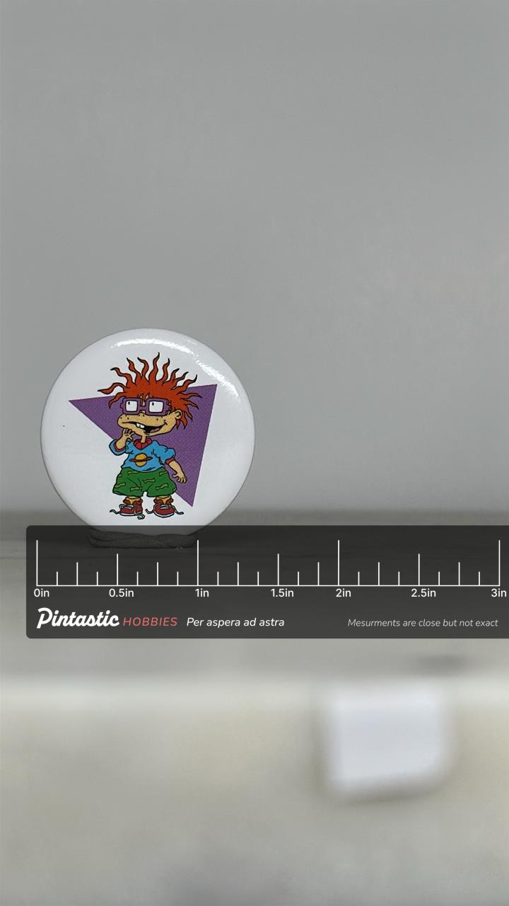 Vintage Rugrats Chuckie Button Pin: Retro Cartoon Style - 90s Nostalgia Accessory with ruler overlay for size reference