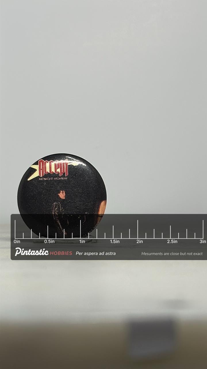 Accept Band Pin: Black Glossy - 1980s Heavy Metal Accessory with ruler overlay for size reference